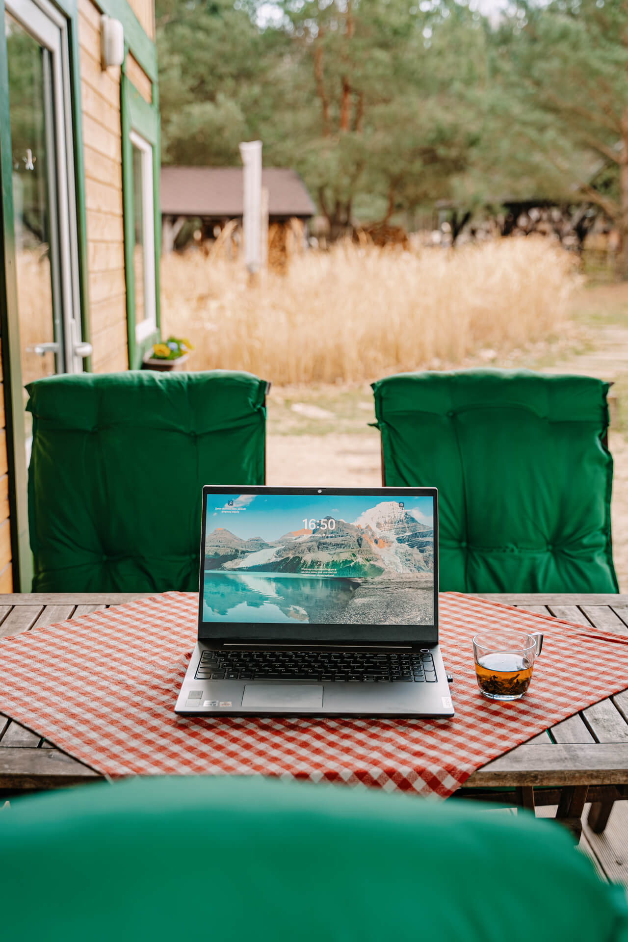 laptop na stole na tarasie całorocznego domku w agroturystyce z wyżywieniem w Borach Tucholskich